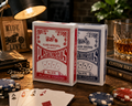 Club Special No.976 plastic coated playing cards in red and blue on a wooden table with poker chips