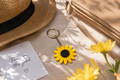 Sunflower keyring on a linen surface with a straw hat, gold purse and yellow flowers