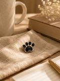 Black paw print enamel pin badge with silver border